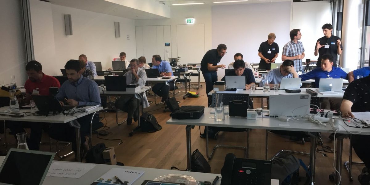 People are working in front of laptops in a classroom